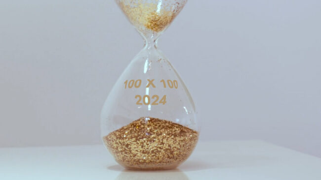 An hour glass with the words 100 x 100 2024- A campaign for Weld Women to Women